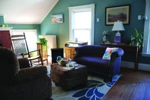 A sunlit room with couches and cozy chairs at The Bridge: A Center for Hope and Healing.