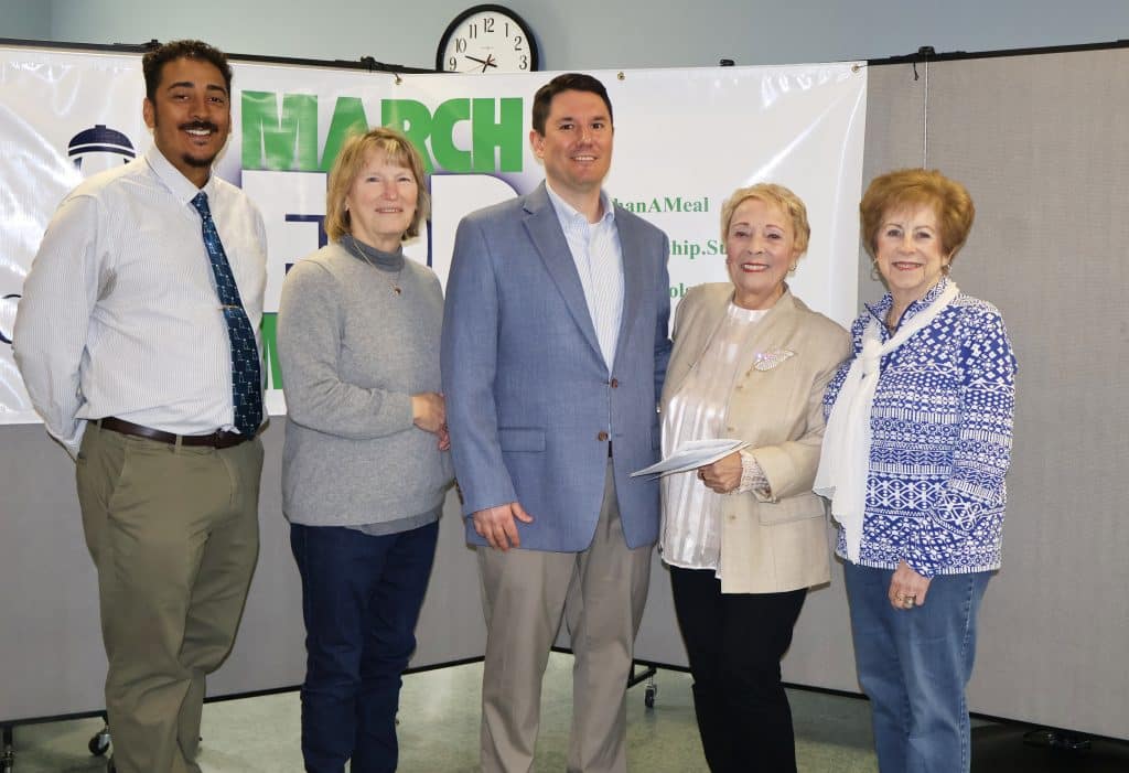 Five people stand in a semi circle looking at the camera for the presentation of a funding check from the Dartmouth Friends of the Elderly to Coastline.